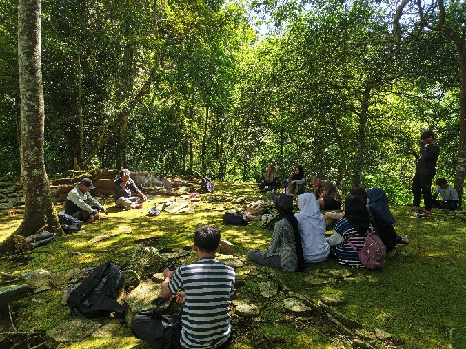 A group of people sitting on grass in the woods

AI-generated content may be incorrect.
